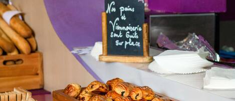 A bakery display with pastries and a sign that reads 'No pains, Vinoiserie, Some Guit, Sur place.'