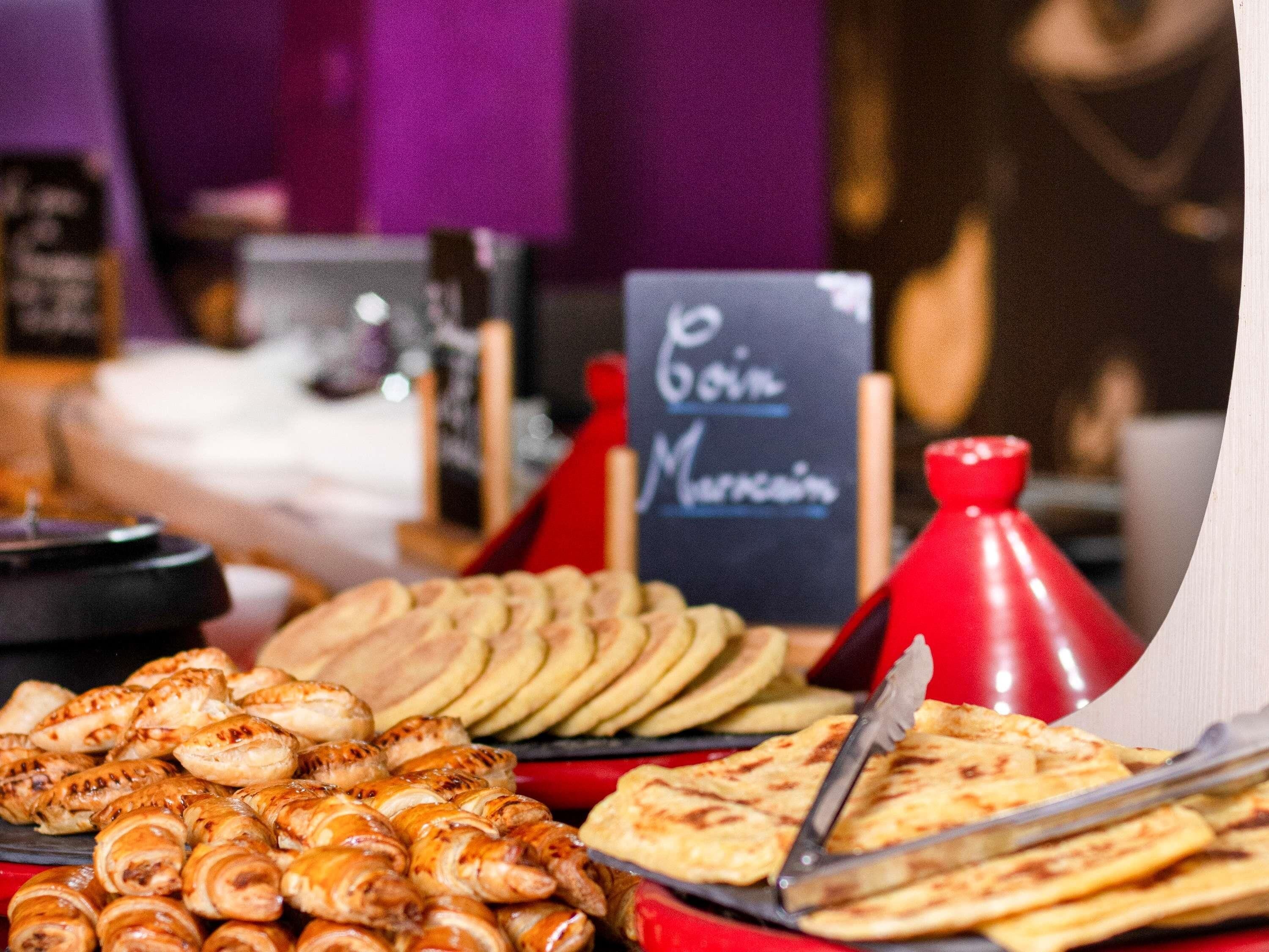Ein Buffet mit verschiedenen Speisen, darunter Gebäck und Fladenbrot.