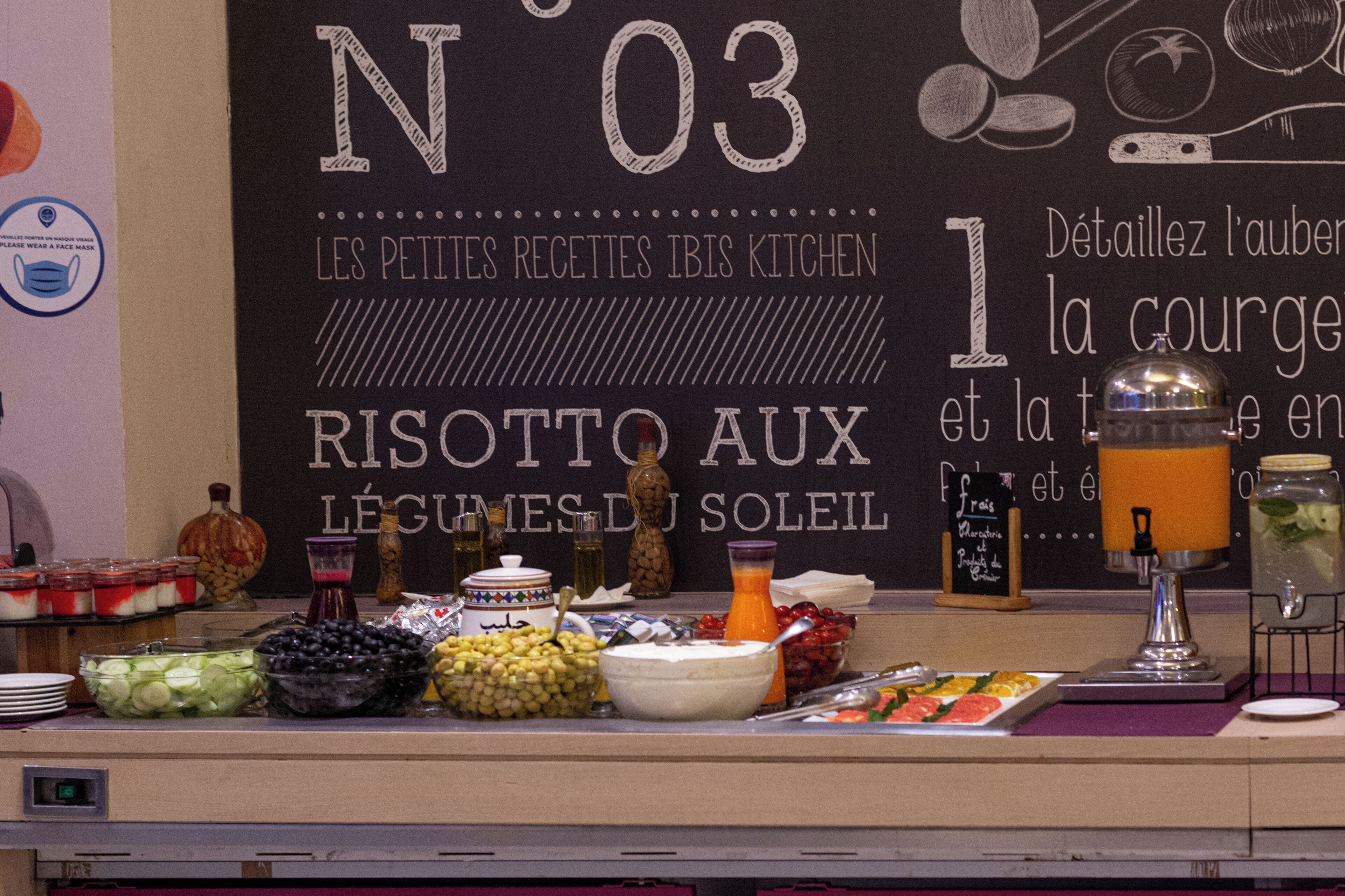 A buffet setup with various food items and a chalkboard menu.