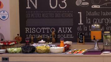 Een buffetopstelling met diverse gerechten en een krijtbordmenu.