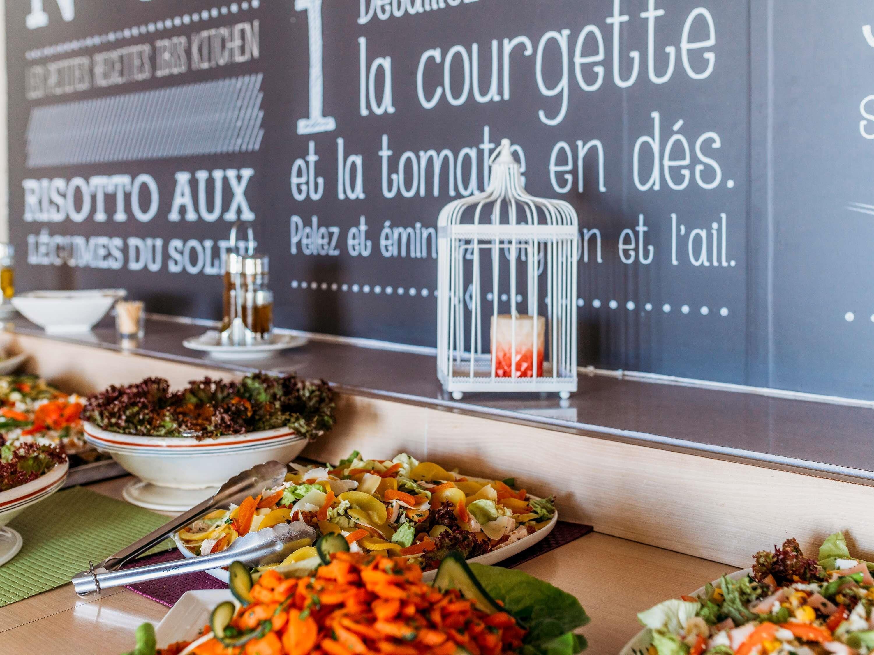 A buffet table with various dishes and a sign in the background.