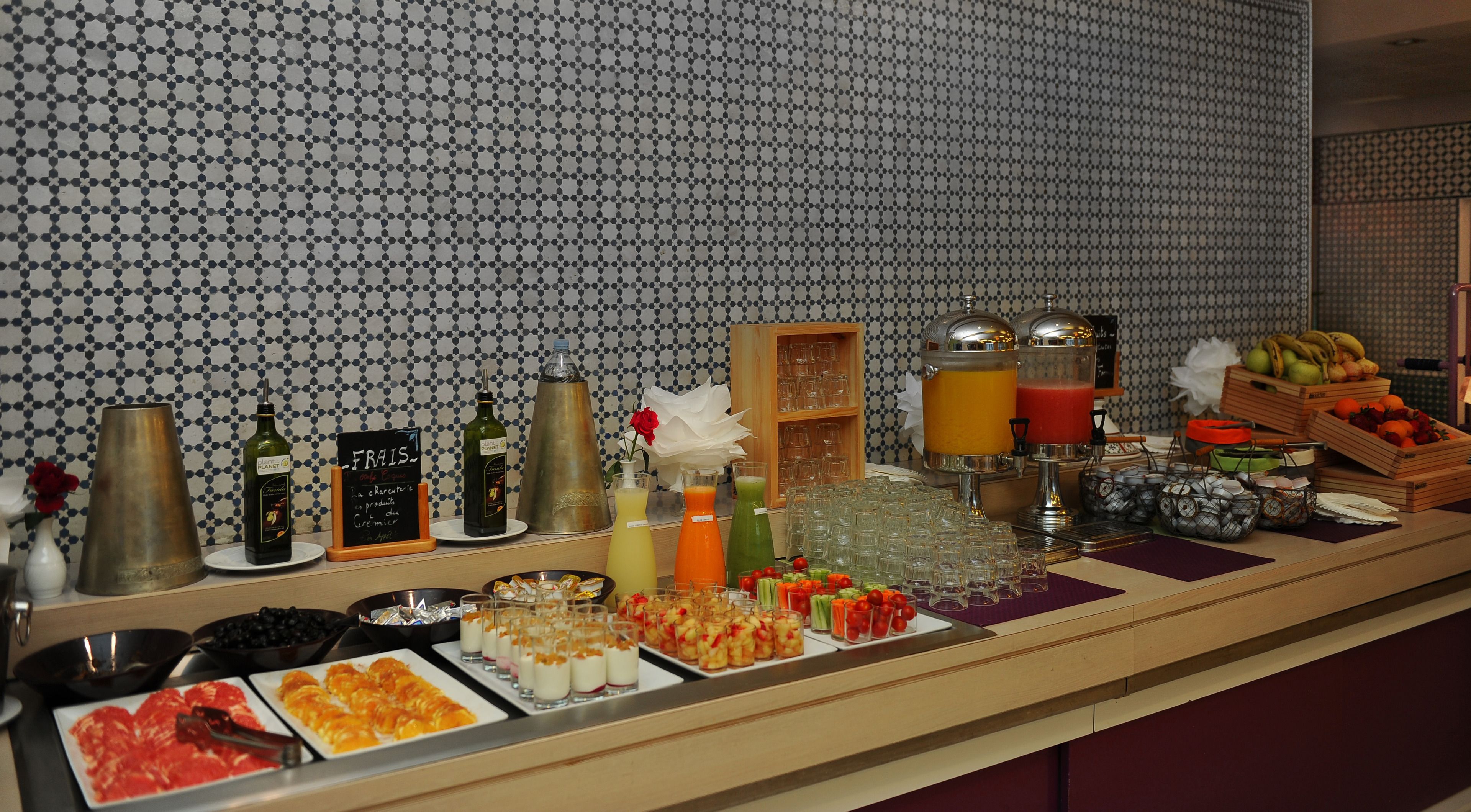 Un buffet proposant une variété de plats, de boissons et un assortiment de fruits.