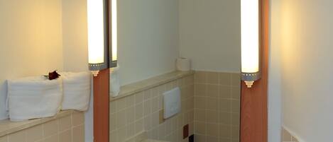 Un bagno con lavandino, specchio, asciugamani e asciugacapelli.