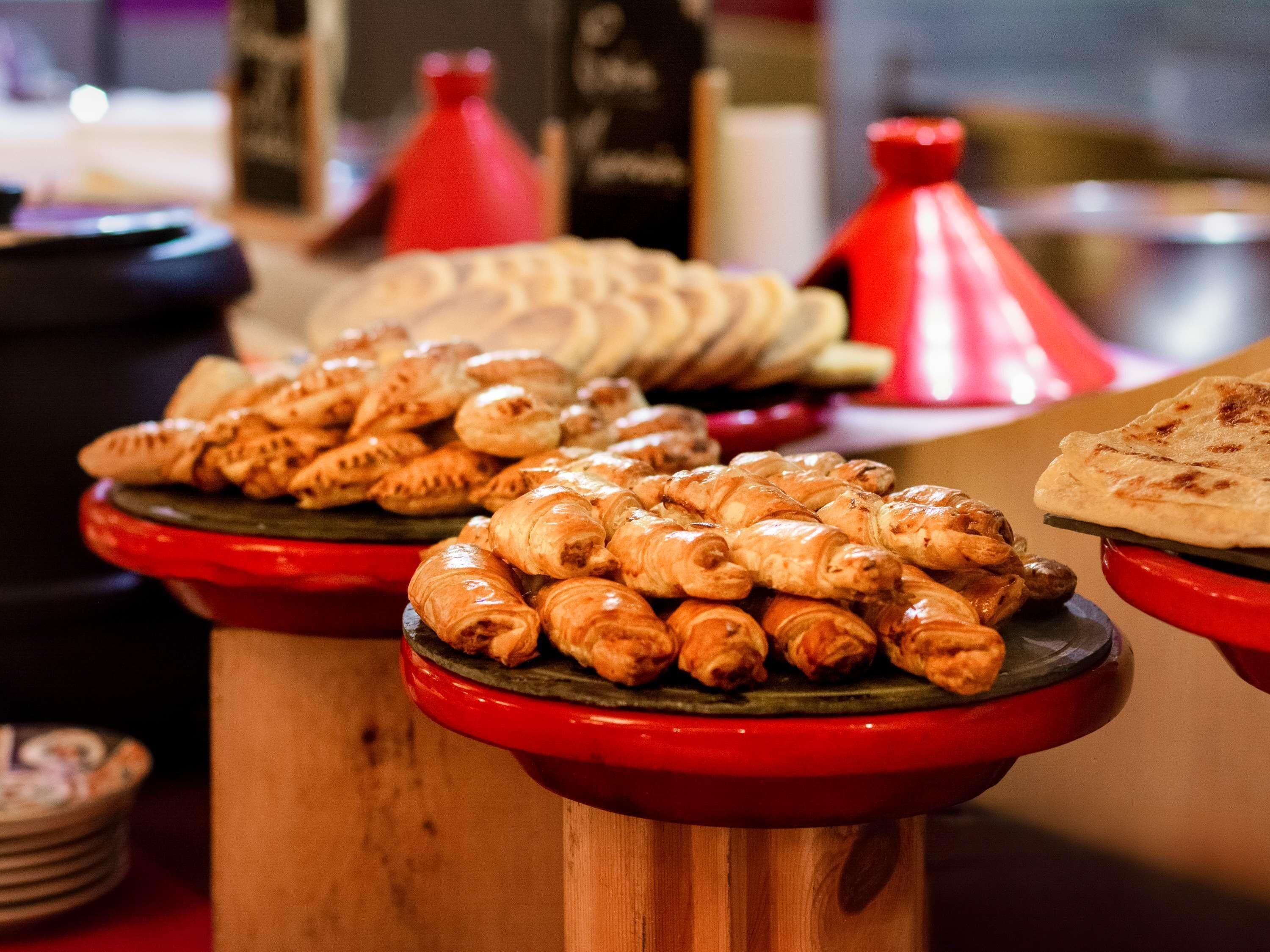 Diverse gebakjes gepresenteerd op houten etagères met rode accenten.