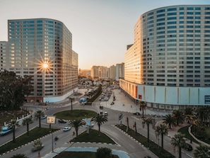 A modern hotel with a curved facade, a central courtyard, and a parking area. - ibis Tanger City Center (Tangier)
