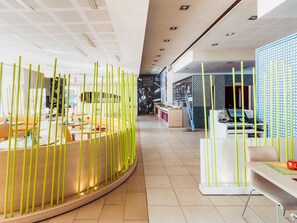 A modern interior with a curved seating area, a reception desk, and a patterned wall. - ibis Tanger City Center (Tangier)