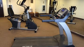 Ein Fitnessstudio mit verschiedenen Trainingsgeräten, darunter Laufbänder und Ergometer.