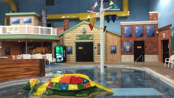An indoor pool area with a colorful inflatable boat, a 'Bunny Jobs' building, and a 'Bank' sign.