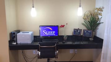 Ein Empfangsschalter mit Computer, Drucker und Schild für Sleep Inn & Suites.
