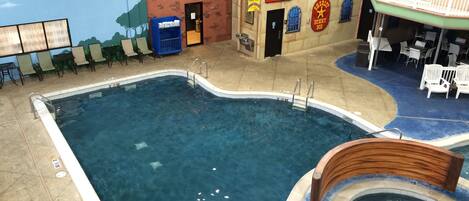 An indoor swimming pool with a lifeguard stand, a play area, and a children's playroom.
