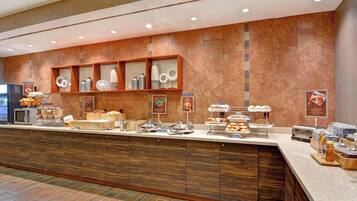 Un mostrador de buffet con diversas opciones de comida y una estación de café.