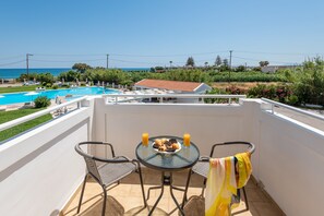 A balcony with a table, chairs, and a view of the sea. - Mrs Chryssana Beach Hotel by GHH (Platanias)