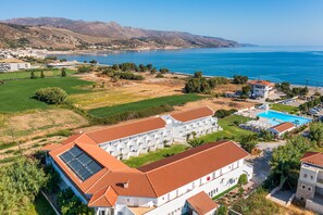 A resort with multiple white buildings, a swimming pool, and a view of the sea. - Mrs Chryssana Beach Hotel by GHH (Platanias)