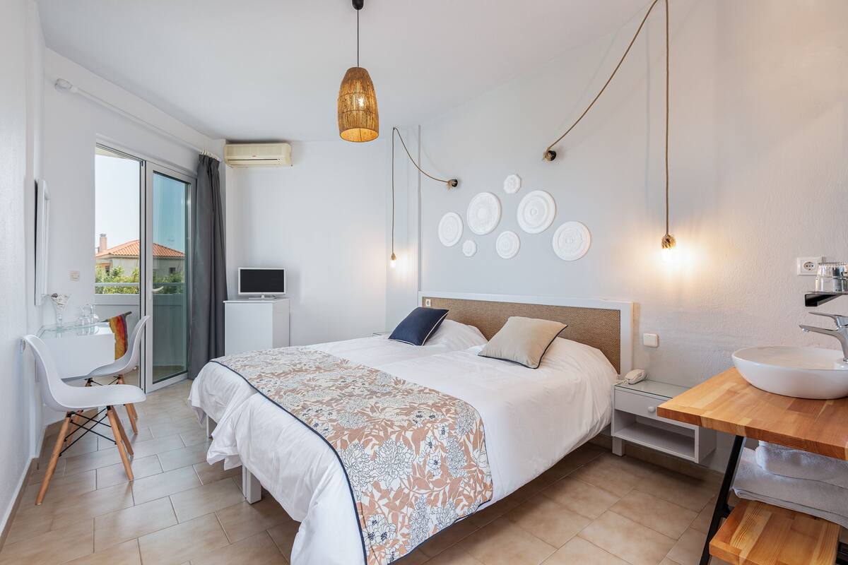 Un dormitorio moderno con cama, mesita de noche y escritorio con silla.