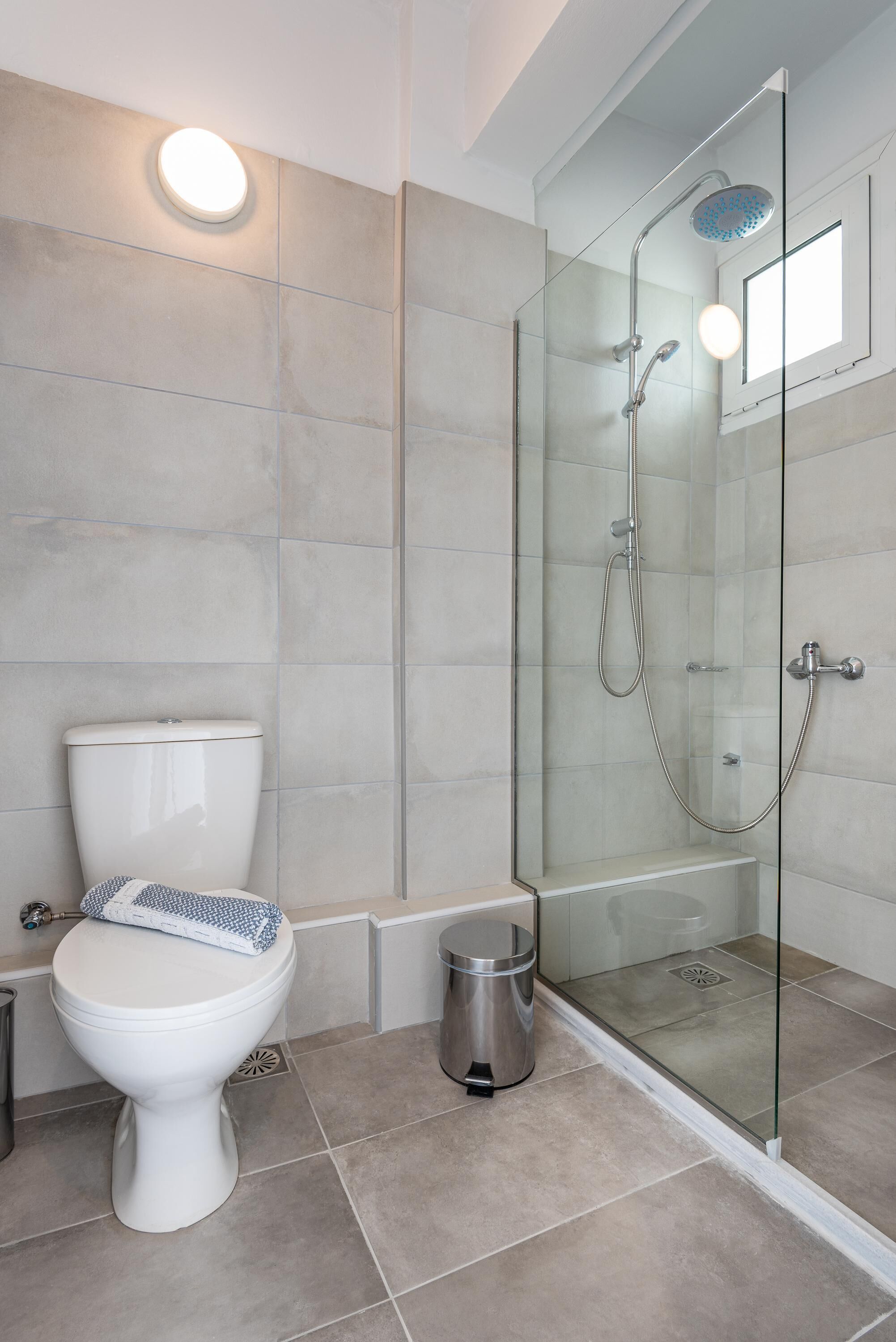 Une salle de bain moderne dotée d’une douche à parois de verre, de toilettes et d’un bidet.