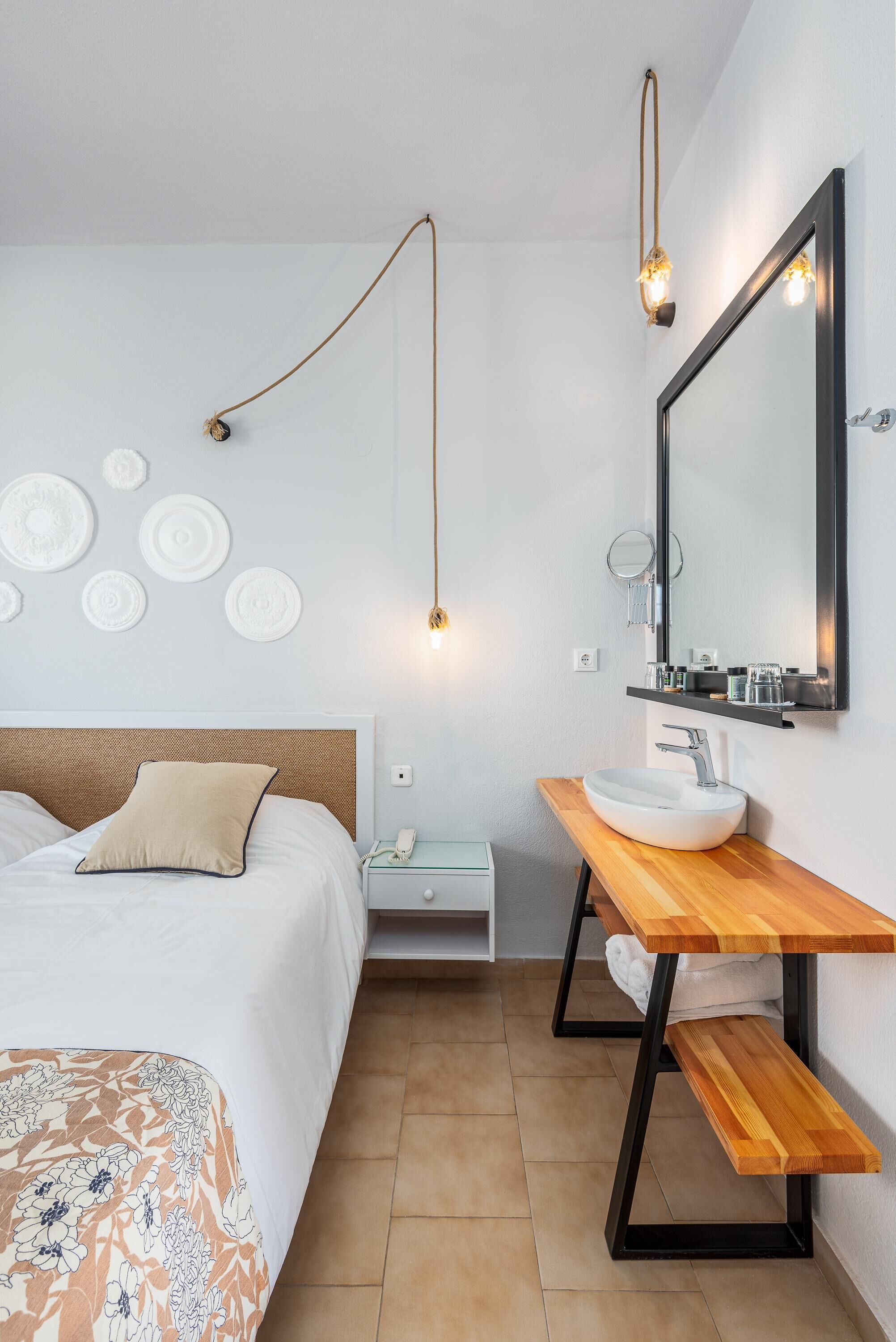 A modern bedroom with a bed, bedside table, and a wooden bench.