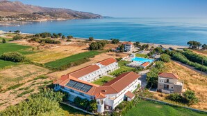 A coastal hotel with multiple buildings, a swimming pool, and a view of the sea. - Mrs Chryssana Beach Hotel by GHH (Platanias)