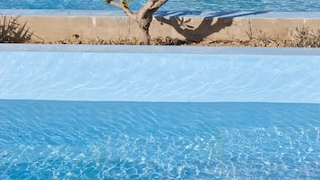 Una piscina al aire libre de temporada, sombrillas