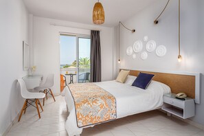 Habitación clásica con 1 cama matrimonial o 2 individuales, vista parcial al mar | Espacio para trabajar con laptop y cortinas blackout 