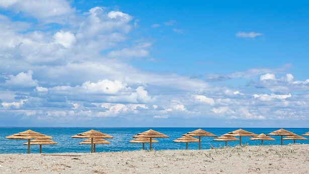 A beach with thatched umbrellas and a clear sky. - Mrs Chryssana Beach Hotel by GHH (Platanias)