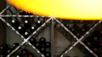 A wine rack with bottles labeled "BAIL" and "GAUL" in a geometric pattern.