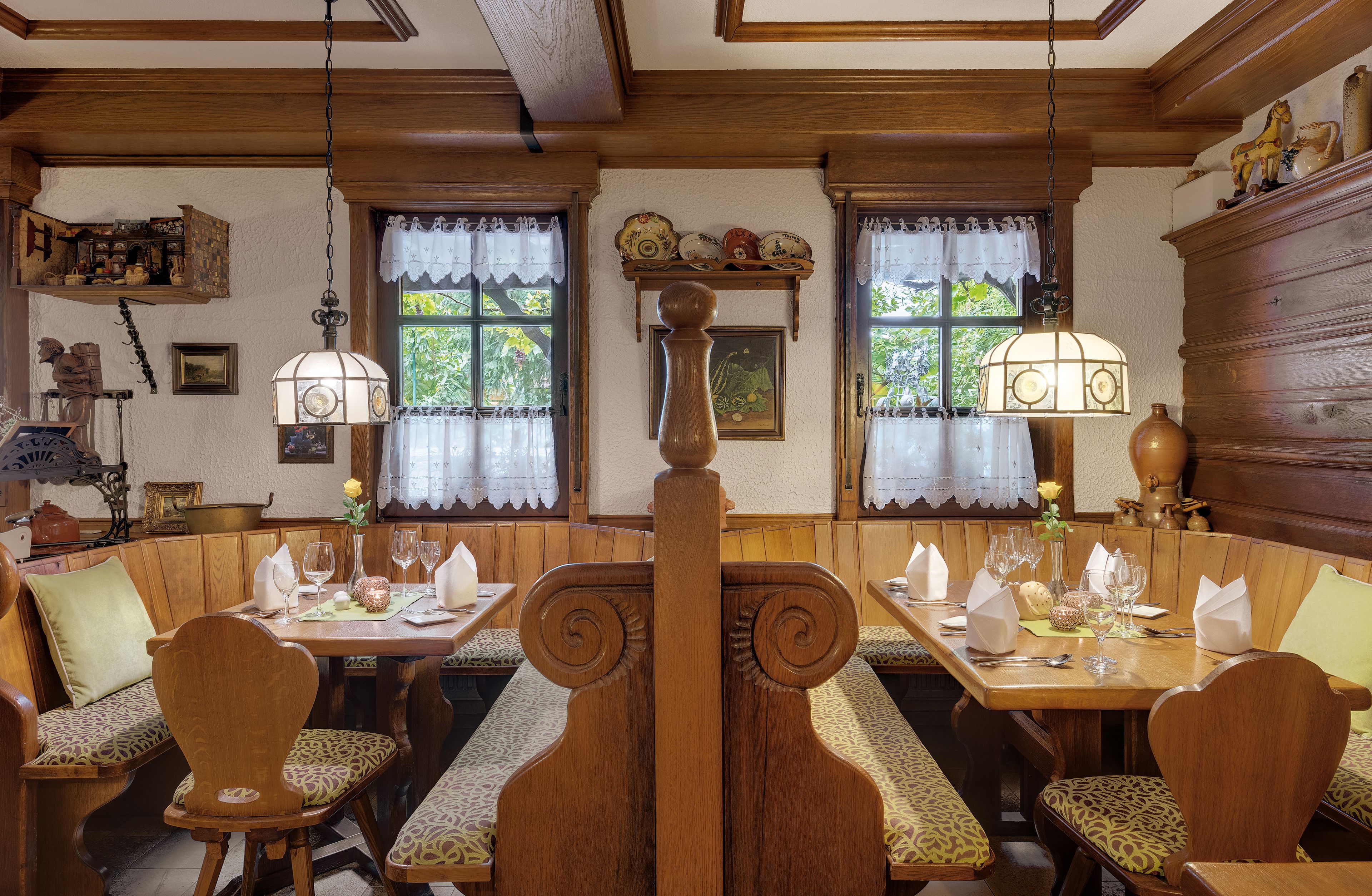 A traditional inn with wooden furnishings, a central bench, and a dining area with tables set for two.
