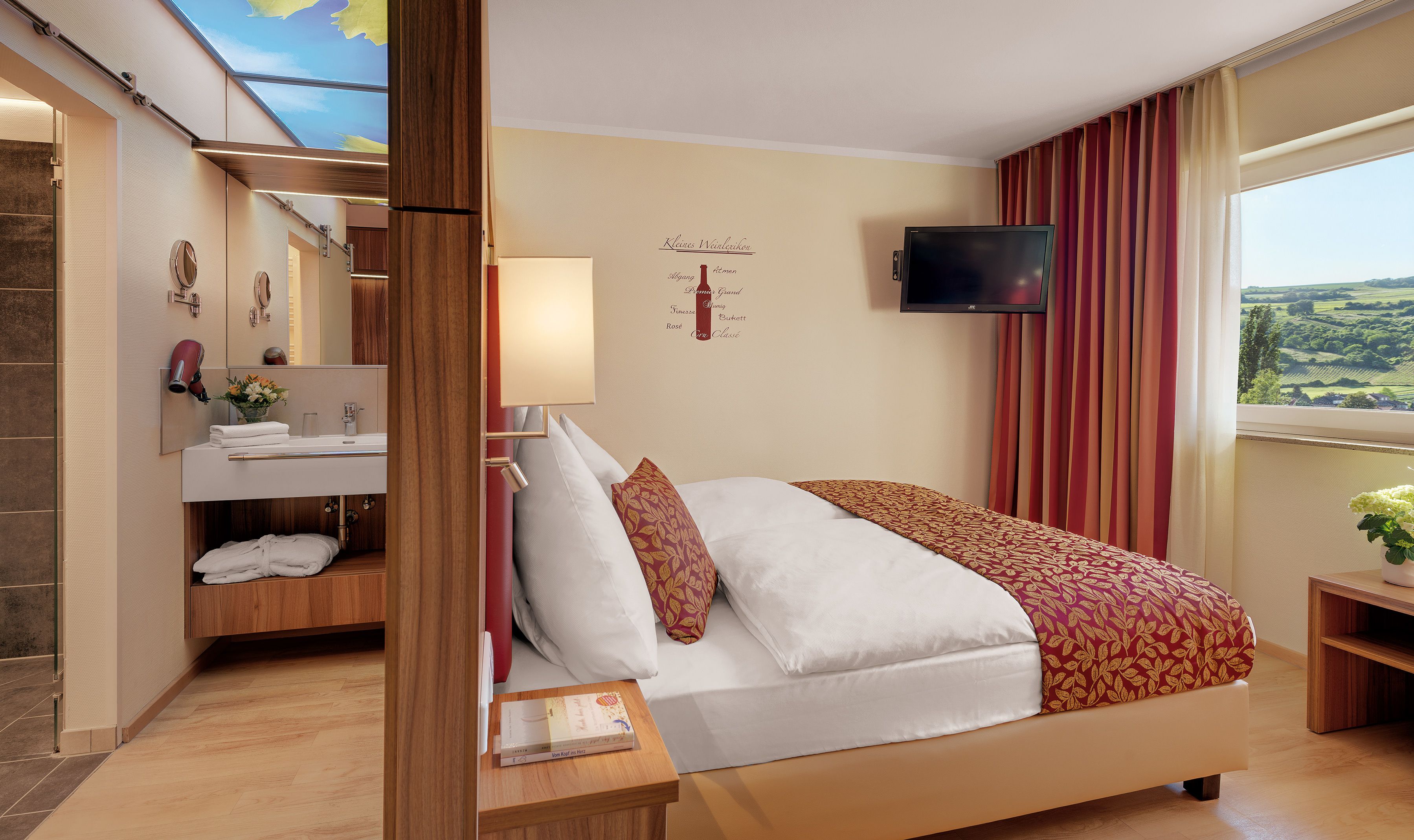 Une chambre d’hôtel comprenant un lit, une télévision, une fenêtre avec des rideaux, une salle de bain avec un miroir et un porte-serviettes.