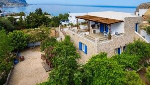 Una casa de piedra con terraza de madera y vista al mar.