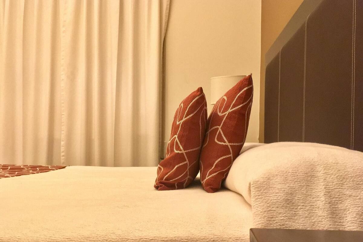 Premium bedding, desk, laptop workspace, blackout drapes