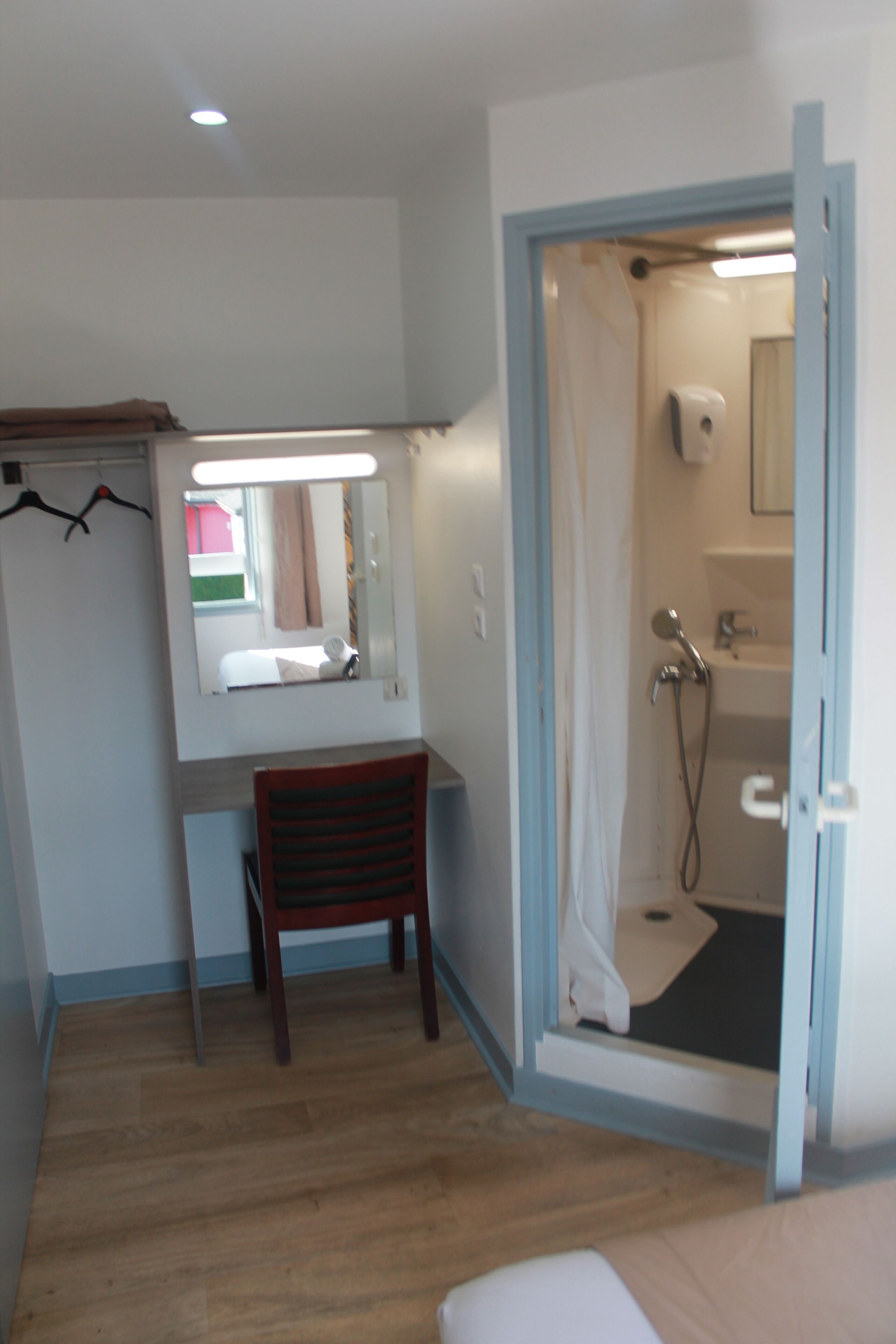 A bathroom with a shower, a sink, and a mirror.