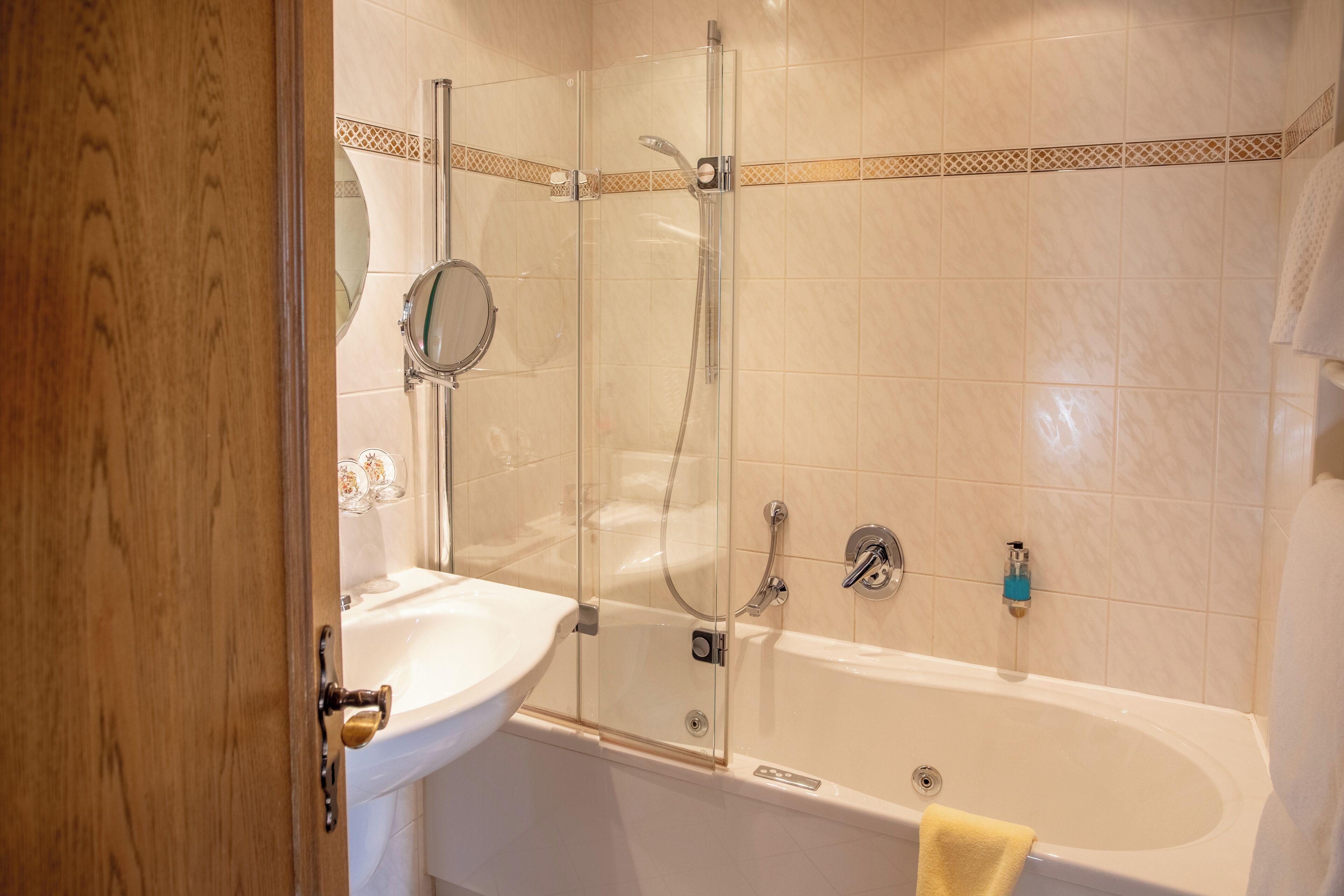 A bathroom with a glass-enclosed shower, a sink, and a bathtub.