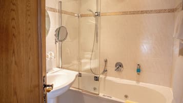A bathroom with a glass-enclosed shower, a sink, and a bathtub.