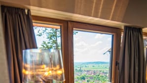 Un escritorio de madera con una lámpara y vistas al paisaje rural a través de una ventana.