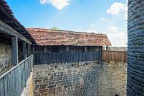 A stone building with a tiled roof and wooden walls.