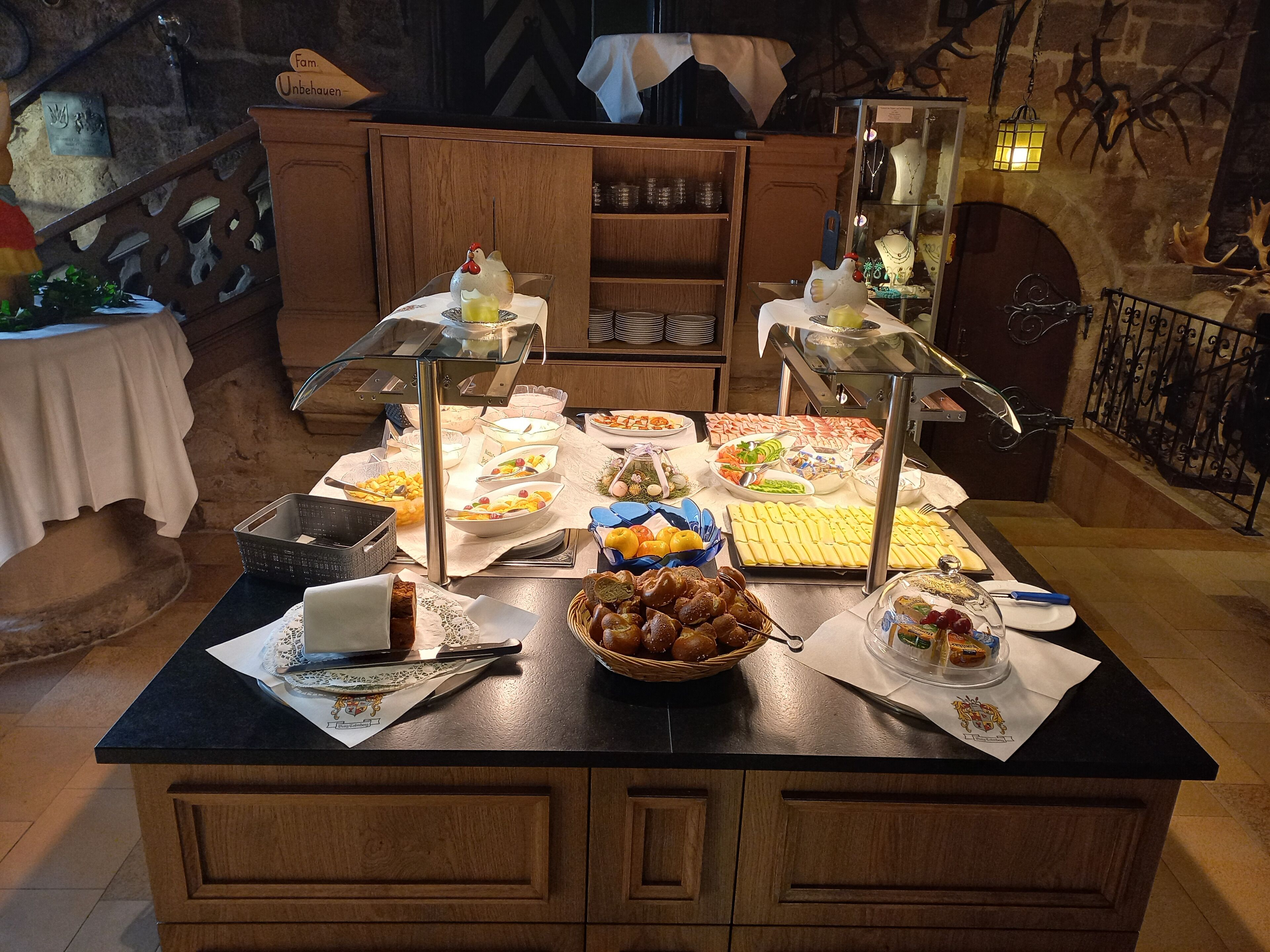 Une table de buffet garnie de divers plats et ornée d’une statuette de poulet décorative.