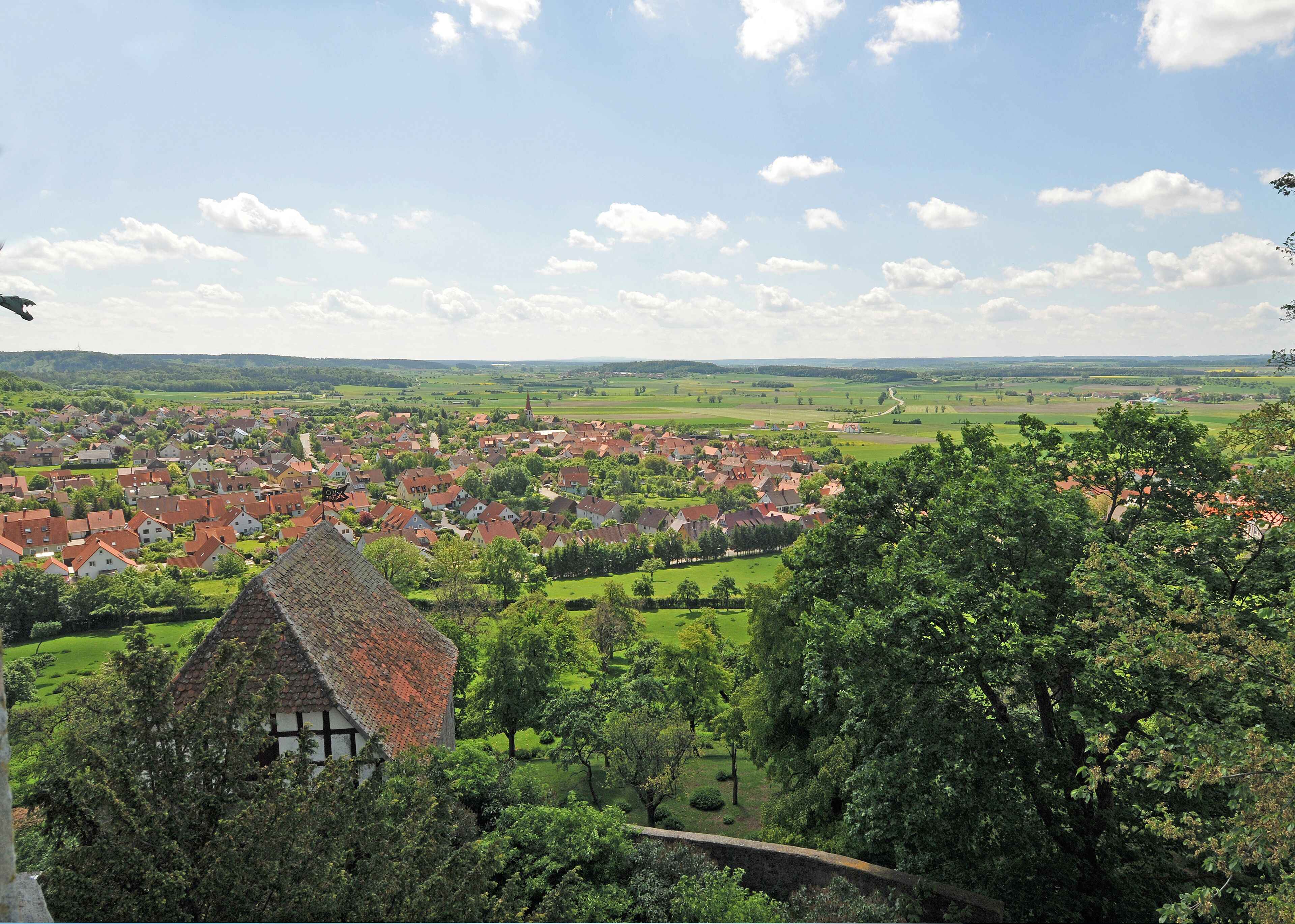 A rural village with traditional houses, a church, and surrounding greenery.