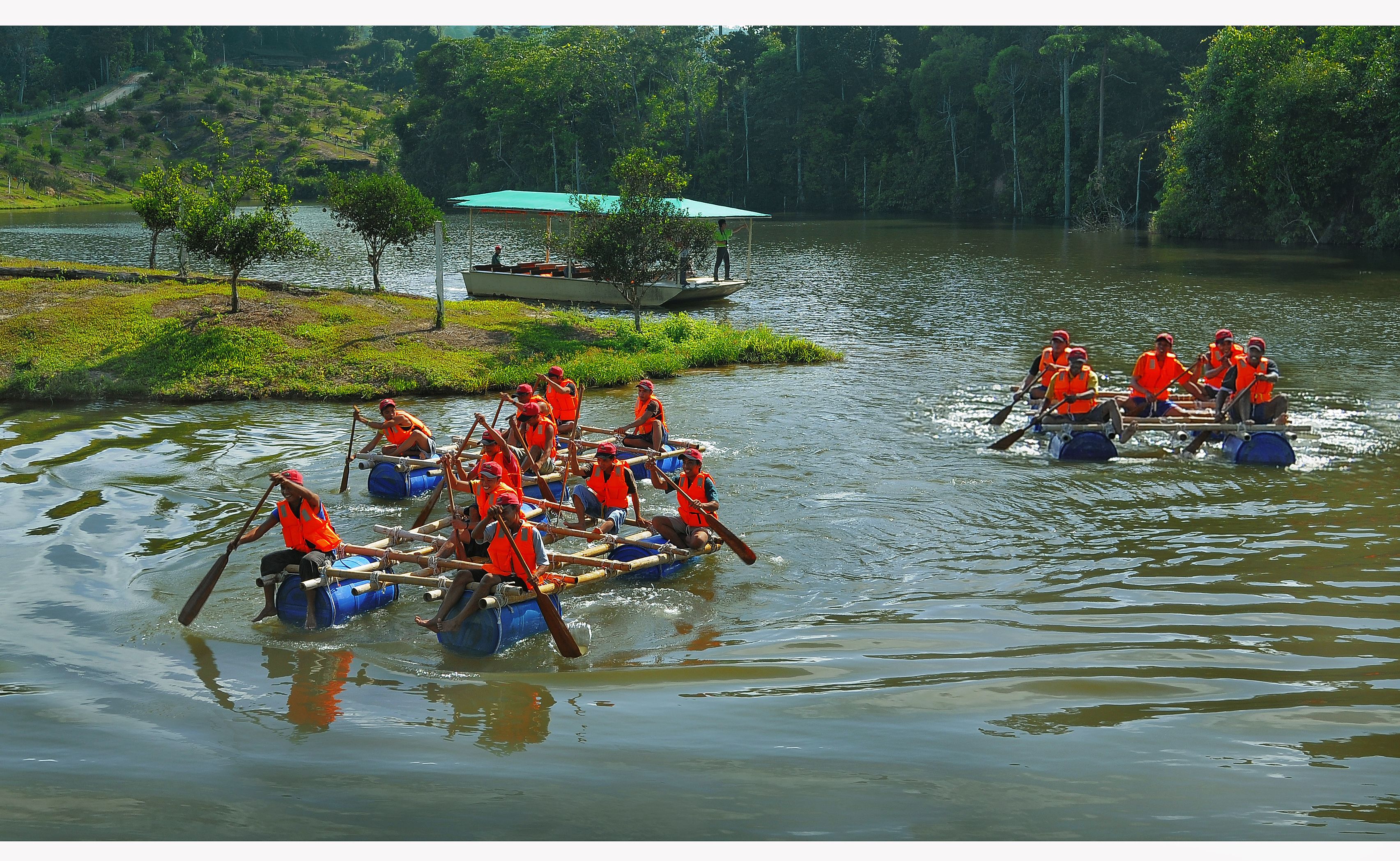 A group of people rowing in canoes on a calm river surrounded by greenery.