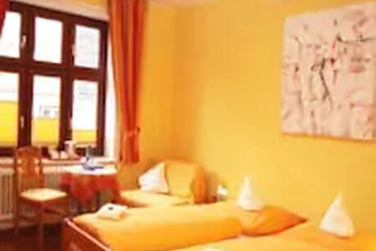A room with two beds, a desk, and a chair.