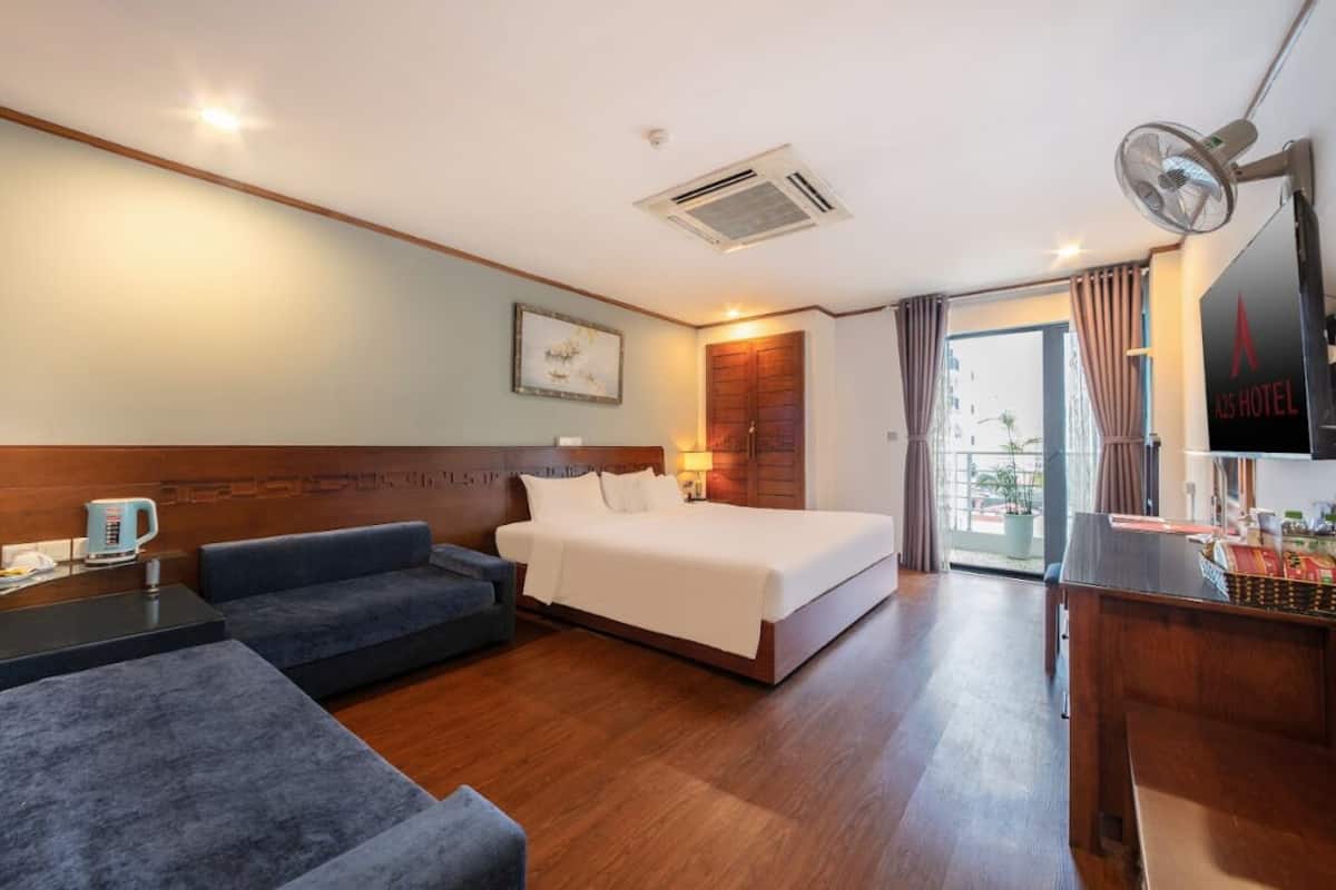 Une chambre d’hôtel équipée d’un lit, d’un canapé, d’un bureau, d’une machine à café et d’une télévision.
