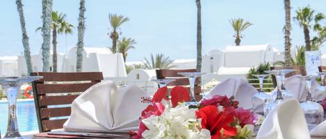 A table set for dining with white napkins, a glass of water, and a flower arrangement.