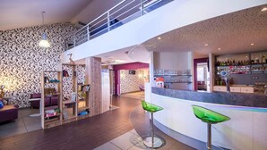 A modern interior with a bar area, seating, and a staircase. - ibis Styles Brive La Gaillarde (Brive-la-Gaillarde)