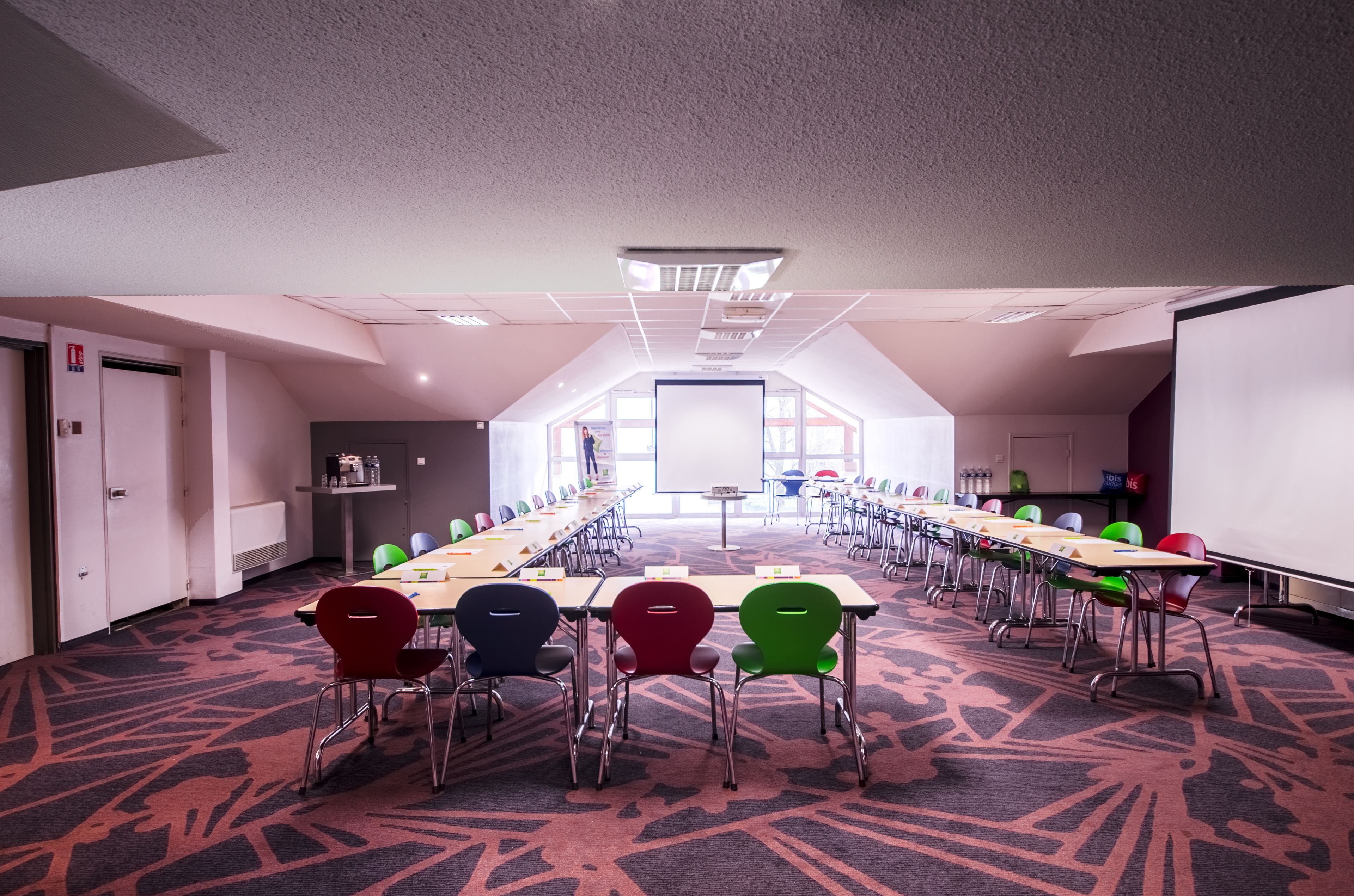A conference room with a long table, multiple chairs, and a whiteboard.
