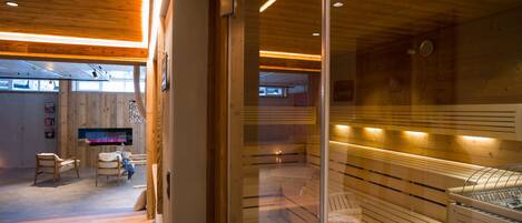 A modern interior with wooden paneling, a seating area with chairs, and a visible fireplace.