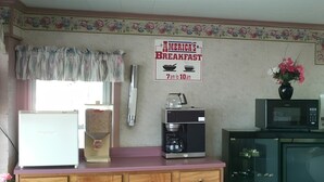 A kitchen with a coffee maker, microwave, and a refrigerator. - America's Value Inn Mexico (Mexico)