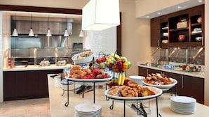 A buffet setup with various food items and a beverage station.