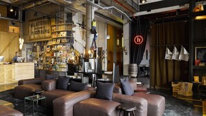 Un espace lounge moderne avec des canapés en cuir, un bar bien garni et un comptoir de réception bien visible.