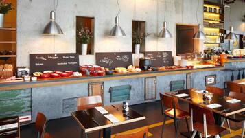 A cafe with a bar area, tables, chairs, and a chalkboard menu.