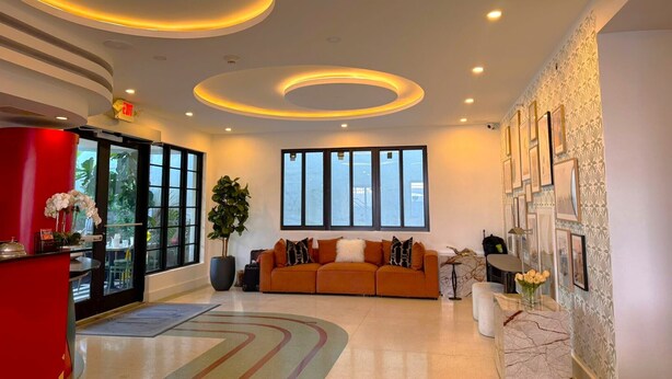 Eine moderne Lobby mit einer Rezeption, einer Couch und einem großen Fenster.