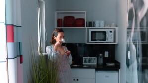 Eine moderne Küche mit weißen Schränken, einer Mikrowelle und einer Kaffeemaschine.