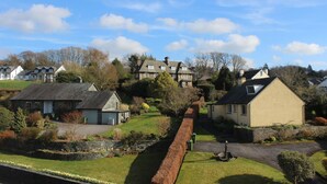 A residential area with houses, a stone wall, and a clear sky. - Invergarry Room Only Guest House (Windermere)